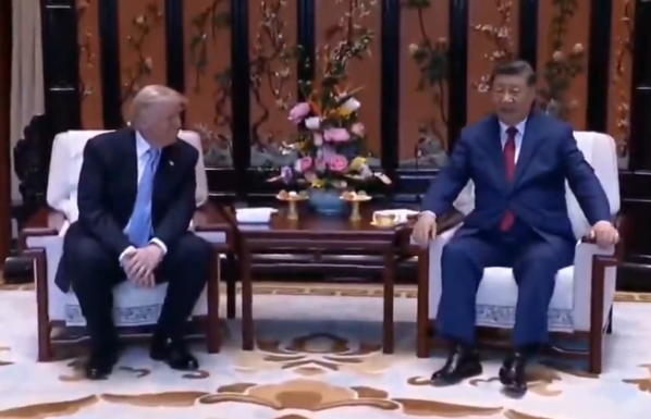 Trump en Xi zitten in een stoel aan weerszijden van een tafel met bloemen erop. Xi zit duidelijk op een hogere stoel dan Trump. 