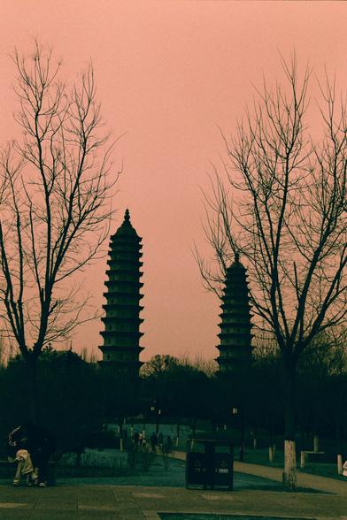 Harman Switch Azure (FF)

English
Silhouettes of two traditional multi-tiered pagodas stand tall against a gradient orange-pink sky. Bare trees frame the scene on both sides. In the foreground, a paved pathway is visible with a few people walking and a trash bin. The atmosphere is serene and calm.
中文
两座传统多层宝塔的剪影矗立在渐变的橙粉色天空下。两侧是光秃秃的树木。前景中，一条铺好的小路可见，有几个人在行走，还有一个垃圾桶。氛围宁静而平和。