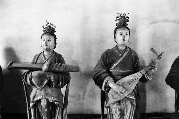 Kentmere PAN 400 (FF)

##English
Black-and-white photograph of two traditional Chinese statues. Both figures are seated and hold musical instruments: the left statue holds a long zither-like instrument, while the right statue holds a pipa (a Chinese lute). Both statues wear traditional robes and ornate headpieces.
##中文
黑白照片，展示两尊传统中式雕像。两尊雕像均为坐姿，手持乐器：左侧雕像持一把长琴状乐器，右侧雕像持琵琶。两尊雕像身着传统长袍，头戴装饰性头饰。