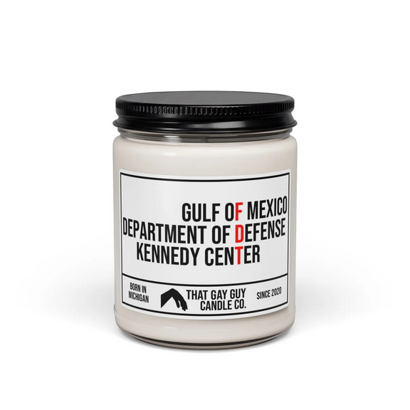 White candle in a jar with a black lid. The label says 
"GULF OF MEXICO 
DEPARTMENT OF DEFENSE
KENNEDY CENTER" with the letters "FDT" picked out in red among the other black text. This is a subtle Fuck Donald Trump.