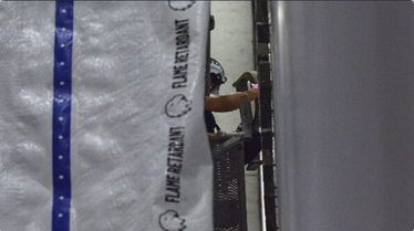 Behind a white tarp, a worker is seen prying the letter "D" from Donald Trump's name off the Kennedy Center