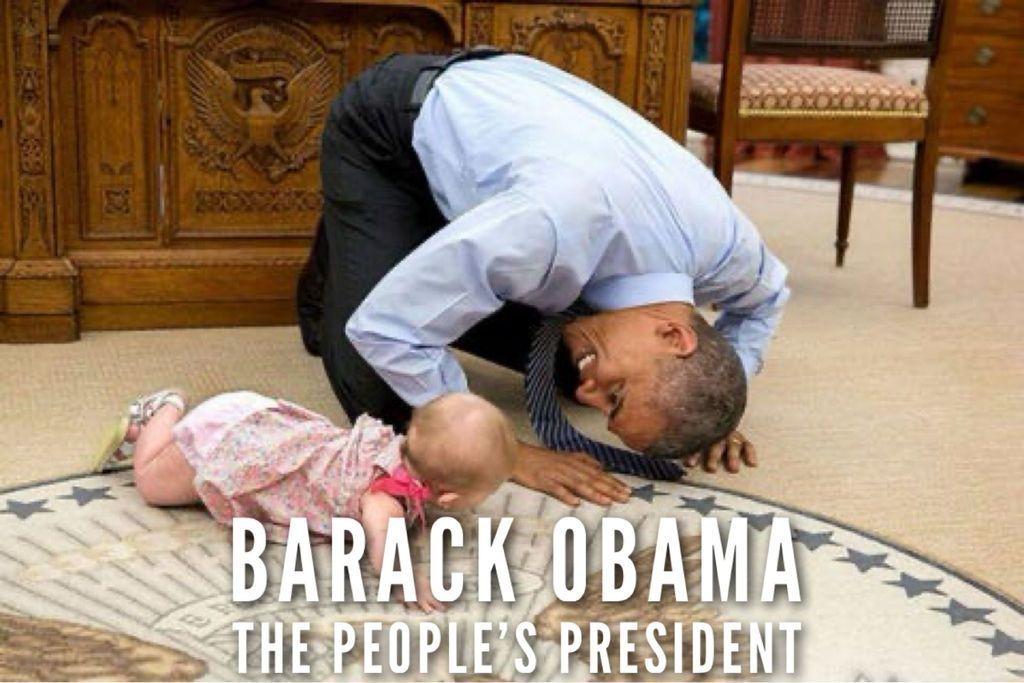 Barack Obama in the Oval Office playing on the floor with a baby. Caption: Barack Obama The People’s President.