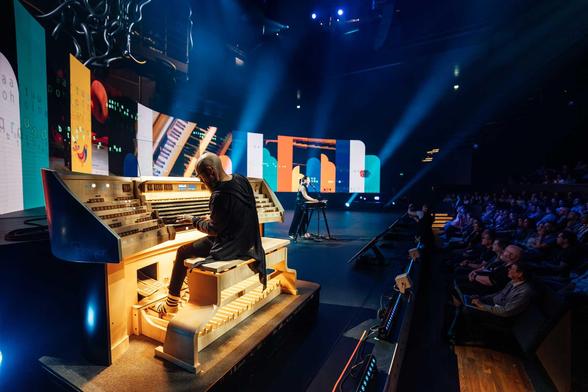 man and woman playing instruments on a big stage