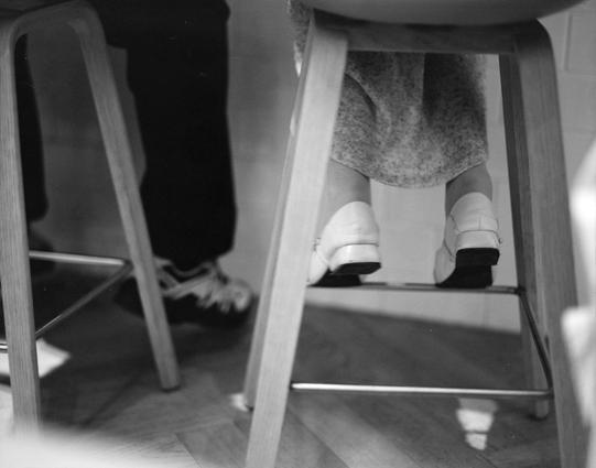 Lucky LUCKY SHD 400 (6x7)

English
Black-and-white photograph of two people sitting on stools. An individual is wearing light-colored clothing, and white shoes. The other is wearing a dark-colored clothing and trainers. The stools are positioned on a wooden floor.
中文
黑白照片，两个坐在凳子上的人。一个人穿着浅色衣物和白色鞋子。另一个人穿这深色衣物和运动鞋。凳子放在木地板上。