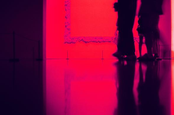 Harman Red 125 (FF)

English
A dimly lit room with a vibrant red and purple glow. The floor is highly reflective, creating a mirror-like effect. Silhouettes of people are visible, with their shadows and reflections adding depth to the scene. A large frame hangs on the wall. The walls are dark, and the light source appears to be a large, illuminated red panel on one side, casting a warm hue over the space.
中文
一个光线昏暗的房间，充满浓烈的红色和紫色光晕。地板具有高反光性，宛如镜面一般。可以看到人们的剪影，他们的影子和倒影为场景增添了深度。墙上有一个大型画框。墙壁较暗，光源似乎来自…