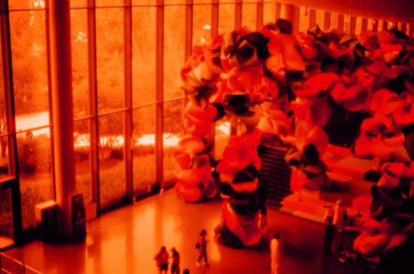 Harman Red 125 (FF)

English
An indoor space with a large, colorful installation made of numerous fabric pieces in shades of red, orange, and pink. The installation fills most of the room, creating a vibrant and dynamic visual effect. Large windows on the left side allow natural light to filter in, illuminating the scene. A few people are visible at the bottom, walking or standing near the installation.
中文
一个室内空间，其中有一个由众多红色、橙色和粉色布料片组成的大型艺术装置。这个装置占据了房间的大部分空间，营造出一种充满活力和动感的视觉效果。左侧的大窗户允许自然光线透入，照亮了整…