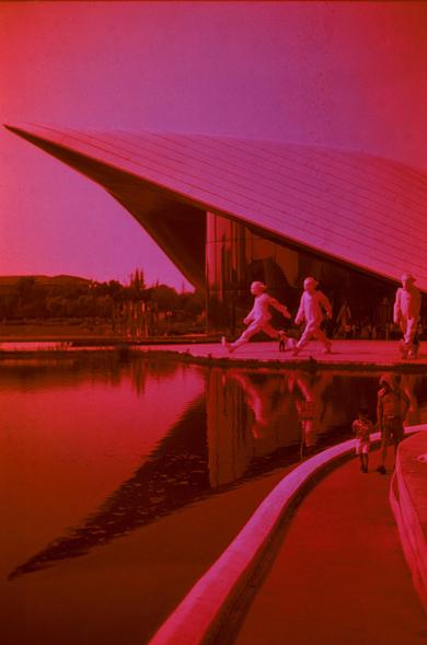 Harman Red 125 (FF)

English
A modern architectural scene featuring a large, white, curved structure with sharp, angular lines. Three human form sculptures stand in front of the architecture.The sky is a gradient of deep pink to purple. In the foreground, a curved walkway runs alongside a body of water. People are walking or running on the path, their figures slightly blurred, adding a sense of motion to the scene.
中文
一个现代建筑场景，主体是一个大型的白色弯曲结构，带有尖锐的角度线条。三个人形雕塑站在建筑前方。天空呈现深粉色到紫色的渐变。前景中，一条弯曲的步道沿着水体延…