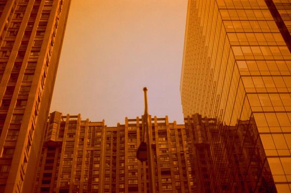 Harman Red 125 (FF)

English
A sepia-toned photograph of a cityscape with tall buildings framing a bright, overcast sky. The buildings are modern, with glass facades, and a lamppost is visible in the center. The image is taken from a low angle, emphasizing the height of the structures.
中文
一张带有暖色调的城市景观照片，高楼大厦环绕着明亮的阴天天空。建筑物现代化，有玻璃外立面，中央有一根灯柱。照片从低角度拍摄，强调了建筑物的高度。