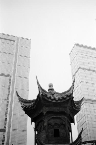 Fujifilm NEOPAN F (FF)

English
A black-and-white photograph of a traditional Chinese pavilion with a multi-tiered, upturned roof. The pavilion is set against a backdrop of modern skyscrapers, creating a stark contrast between old and new architectural styles. The sky is bright, emphasizing the silhouette of the pavilion.
中文
一张黑白照片，展示了一个中国传统亭台，其屋顶为多层且向上翘起的样式。亭台以现代摩天大楼为背景，形成了古老与现代建筑风格的强烈对比。天空明亮，突显了亭台的轮廓。