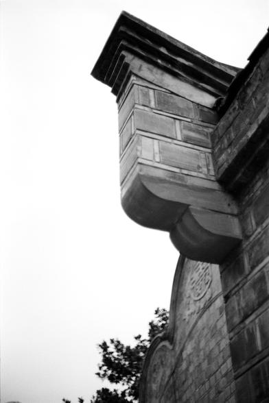 Fujifilm NEOPAN F (FF)

English
A black-and-white photograph of the corner of a traditional Chinese building. The image captures the intricate layered eaves and brickwork of the structure. The roof tiles are curved, and the bricks are arranged in a precise, geometric pattern. A small portion of a tree is visible in the lower left corner.
中文
一张黑白照片，拍摄的是中国传统建筑的一个角落。图像展示了建筑精美的多层屋檐和砖墙。屋顶的瓦片呈弯曲状，砖块排列成精确的几何图案。左下角可见一小部分树木。