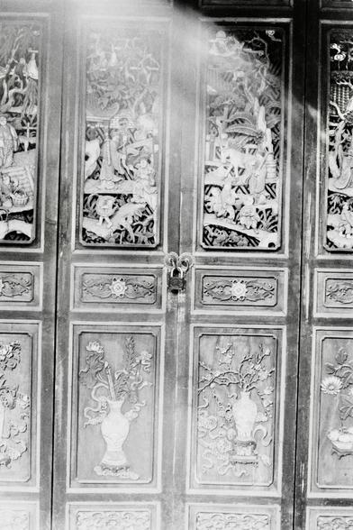 Lucky LUCKY SHD 400 (FF)

English
A black-and-white close-up photograph of intricately carved wooden doors. The doors feature multiple panels with detailed relief carvings depicting scenes of people, animals, and nature, such as trees, flowers, and vases. The carvings are highly detailed, showcasing traditional craftsmanship. A lock is visible in the center of the doors.
中文
一张黑白特写照片，展示了精美雕刻的木门。门上有多个面板，上面的浮雕精细地描绘了人物、动物和自然场景，如树木、花朵和花瓶。雕刻非常细腻，展现了传统工艺。门的中央可见一把锁。