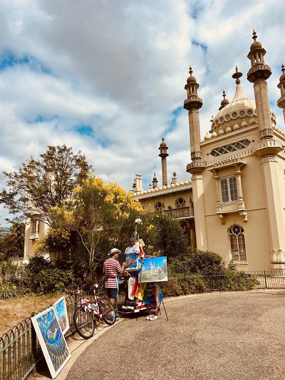 Artist paints exterior of Brighton Pavilion which is golden sandy colour in an opulent British take on oriental design