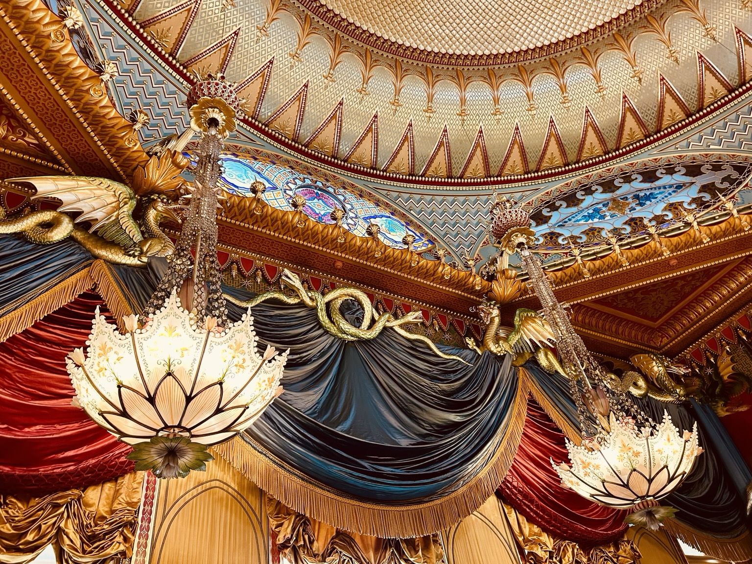 A stunning ceiling with dragons, giant hanging almost Tiffany style lamps. The colours are rich reds, gold and turquoise.
