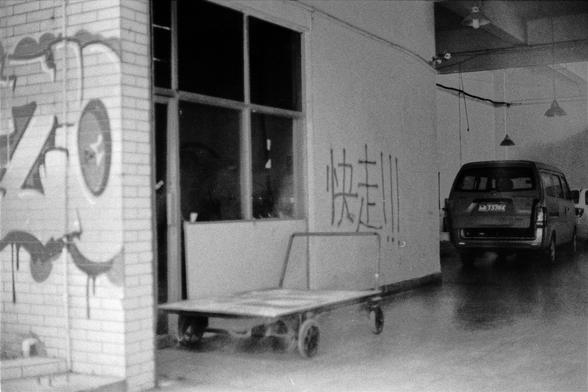 Lucky LUCKY SHD 400 (FF)

English
A black-and-white photograph of an indoor space with a brick wall on the left, featuring graffiti and a circular design. A large window is visible in the center, with Chinese characters written on the wall to its right. A flatbed trolley is parked in front of the window, and a van is visible in the background on the right side of the image.
中文
一张黑白室内空间照片，左侧是一面砖墙，墙上有涂鸦和一个圆形设计。中间有一扇大窗户，其右侧的墙上写有中文字符。窗户前停放着一辆平板推车，图片右侧背景中可见一辆面包车。