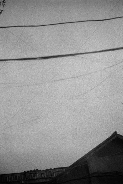 Lucky LUCKY SHD 400 (FF)

English
A black-and-white photograph of a sky filled with crisscrossing power lines. Below the lines, the rooftops of buildings are faintly visible in the lower portion of the image.
中文
一张黑白照片，展示了布满交叉电线的天空。在电线下方，图片的下方部分可以隐约看到建筑物的屋顶。