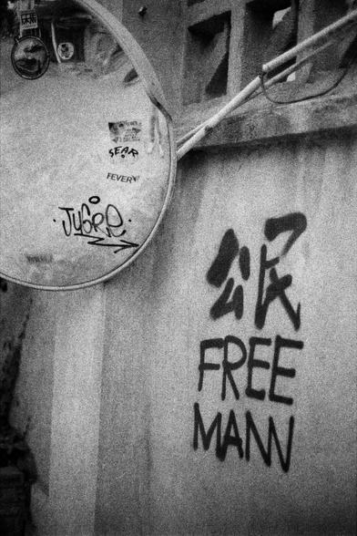 Lucky LUCKY SHD 400 (FF)

English
A black-and-white close-up of a wall with graffiti. The graffiti includes the text "FREE MANN" in bold, large letters, with additional smaller graffiti tags on a circular object attached to the wall.
中文
一张黑白色调的墙壁特写，墙上有涂鸦。涂鸦包括粗体大字“FREE MANN”，此外在附着于墙上的一个圆形物体上还有较小的涂鸦标记。