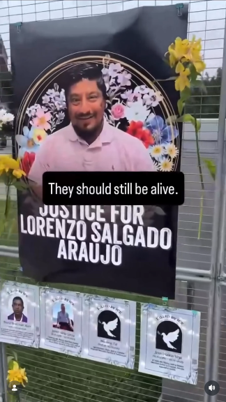 A large wire stand holds images of the dozens of people who've been murdered by ICE recently. There's a big black poster that says "JUSTICE FOR LORENZO SALGADO ARAUJO" that shows his smiling image surrounded by flowers. People have also put real flowers in the wire structure. Along the bottom are pages of paper with the names of other victims, some of whom don't have images available so are symbolized with white doves on a black background.

A text box in the center says "They should still be alive."