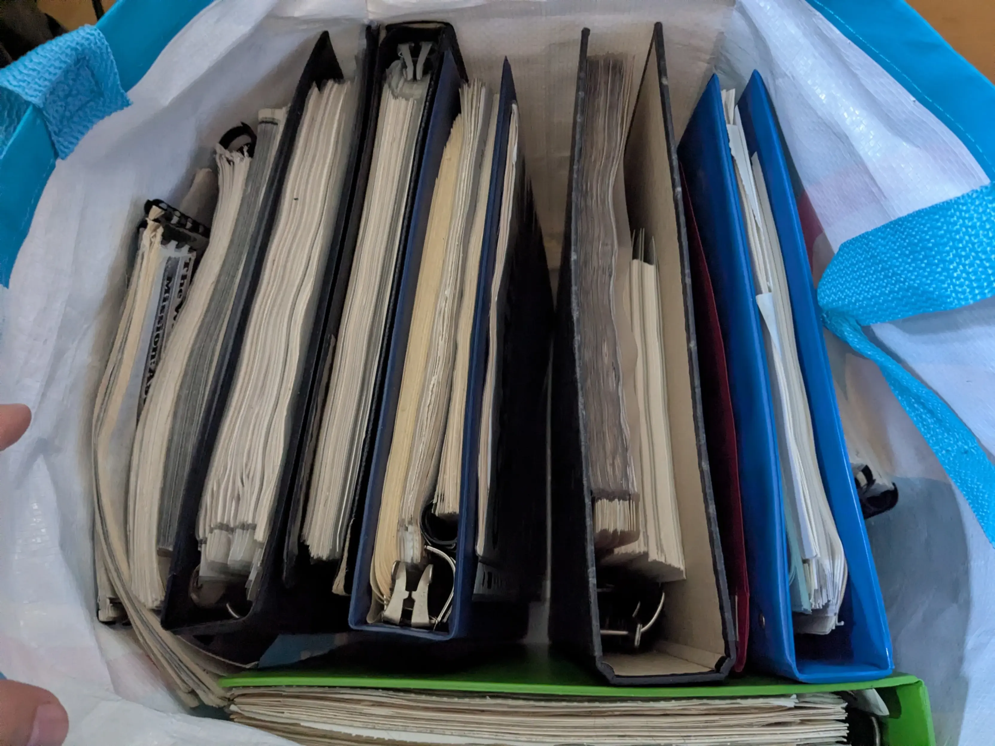 A supermarket bag full of old file binders