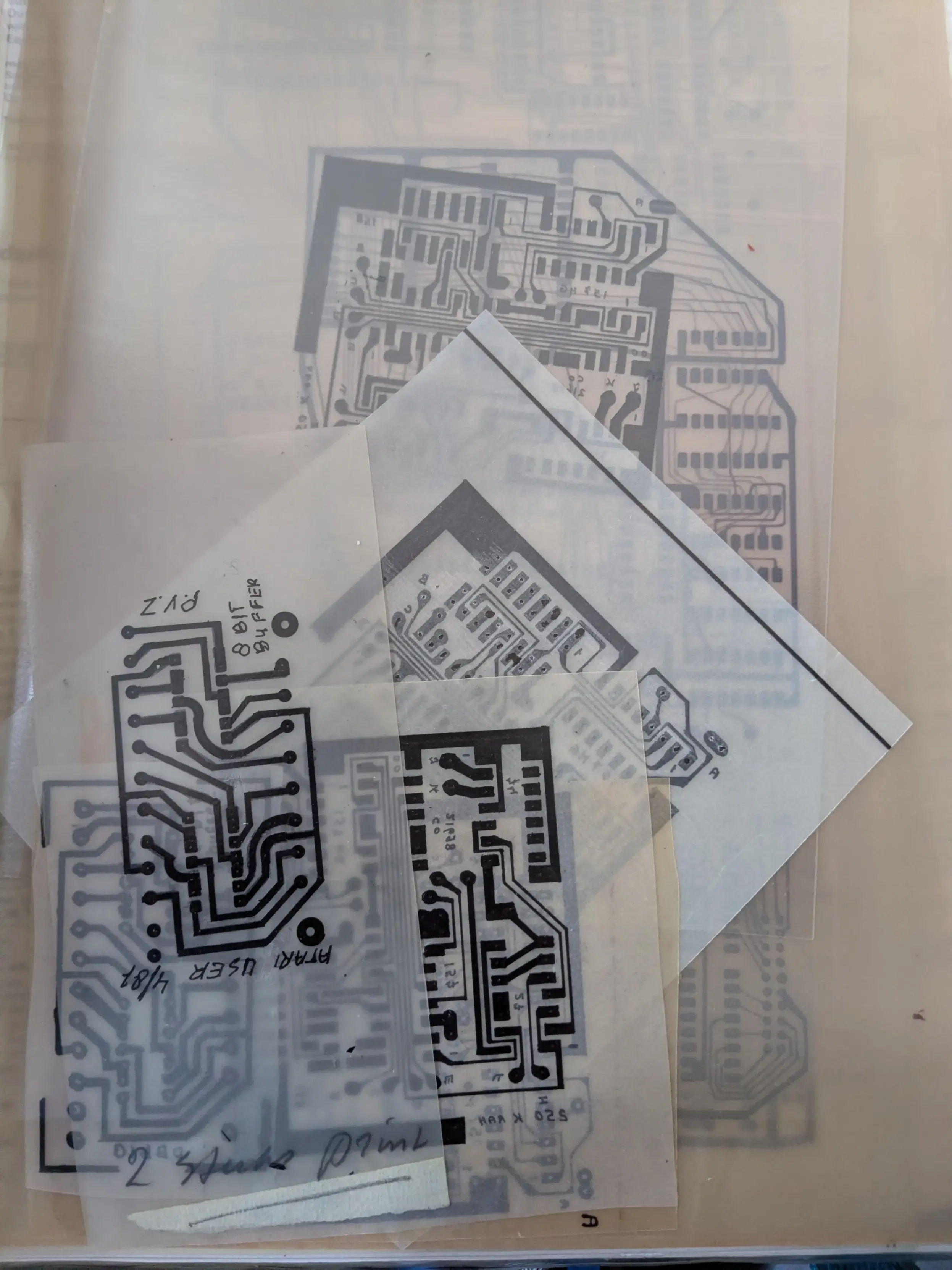 A stack of PCB etching masks, clear plastic sheets with the layouts of printed circuit boards.