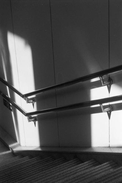 Ilford FP4 Plus 125 (FF)

English
A black-and-white photograph of a staircase with metal handrails. The handrails are mounted on a plain, light-colored wall, casting distinct shadows. The staircase is a patterned design, and the image captures the interplay of light and shadow on the steps and railings, creating a geometric and abstract visual effect.
中文
一张黑白照片，展示了一个带有金属扶手的楼梯。扶手安装在一面素色的浅色墙上，投下清晰的阴影。楼梯铺有带图案, 照片捕捉了光线和阴影在台阶和扶手上的相互作用，营造出几何和抽象的视觉效果。