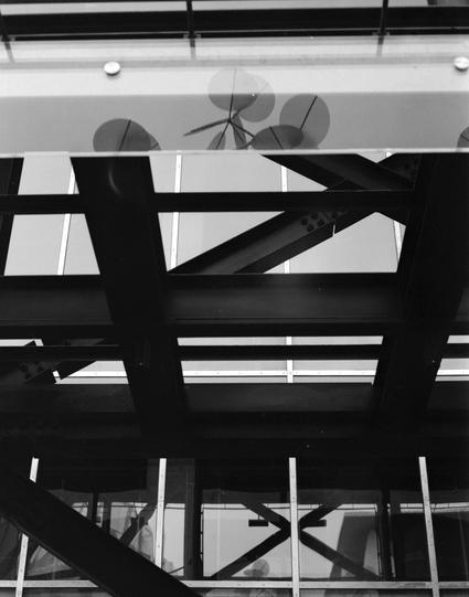 Lucky LUCKY SHD 400 (6x7)

English
A black-and-white photograph of the interior of a modern building, focusing on its ceiling. The ceiling features a geometric pattern of intersecting steel beams and glass panels. Visible through the glass are parts of ceiling fans or light fixtures.
中文
一张黑白照片，聚焦于一座现代建筑的内部天花板。天花板呈现出由交叉的钢梁和玻璃面板组成的几何图案。透过玻璃可以看到天花板风扇或灯具的部分。