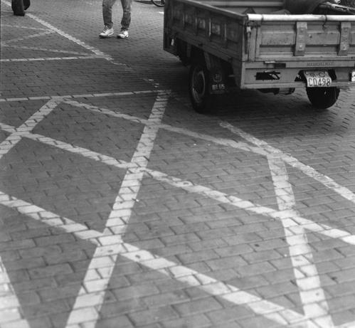 Lucky LUCKY SHD 400 (6x7)

English
A black-and-white outdoor scene showing a paved area with white diagonal lines marking parking spaces. A small utility truck is parked, with its license plate reading "CD498." One individual is walking nearby, wearing light-colored shoes and jeans.
中文
黑白户外场景，展示了一个铺设有白色对角线的停车场。一辆小型货车停在停车位上，车牌号为“CD498”。附近有一个人在行走，穿着浅色鞋子和牛仔裤。