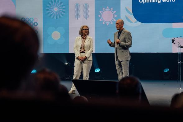 a man and a woman presenting on.a big stage