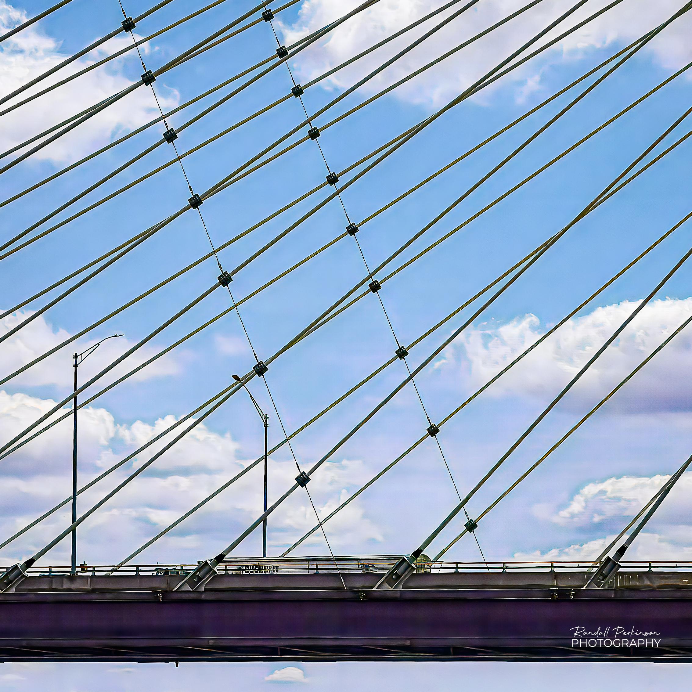 A top of a truck in the far lanes can be seen as it crosses the Mississippi River bridge at Cape Girardeau, Missouri.  Above the deck are all of the cable stays that reach up to the tall tower to support the deck.