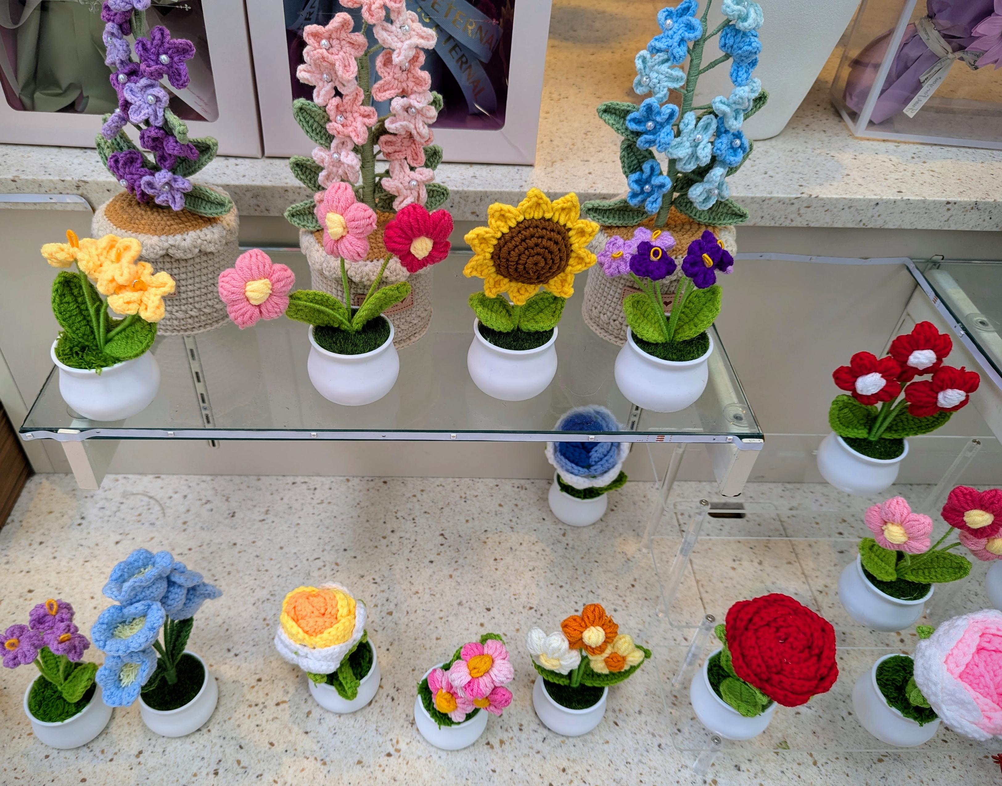 Kiosk display of small ornamental flower sculptures.