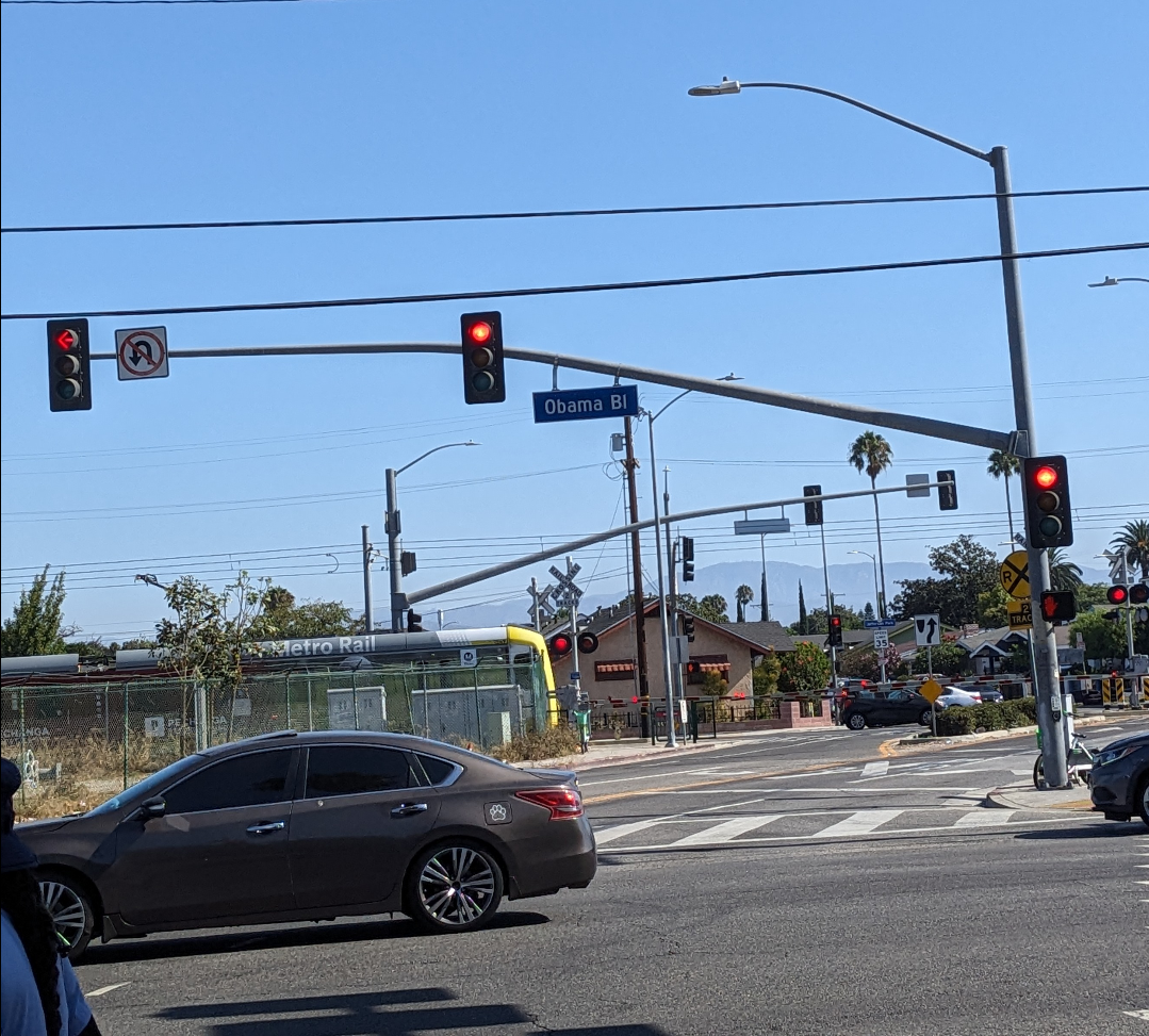 Train passing behind cars at a busy intersection
