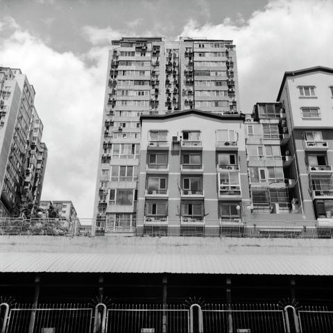 Lucky LUCKY SHD 100 (6x6)

English
A black and white photograph of a group of high-rise residential buildings against a cloudy but bright sky. The buildings have a unique structure and seem to stand on an elevated bridge or on top of a tunnel. Under the buildings, a dark tunnel is visible with fences on the border of the tunnel.

中文
一張黑白照片.照片中是一組高層住宅樓.住宅樓背面是晴朗但多雲的天空.這些樓的設計獨特,似乎是站在一個架空的橋或者隧道上方.樓的下方是一個黝黑的隧道,邊上有金屬圍欄.