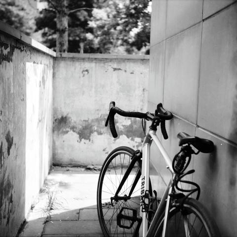 Lucky LUCKY SHD 100 (6x6)

English
A black and white photograph. A bicycle is parked by the side of a grid-patterned wall, which is right to a concrete made tunnel. There seems to be dense foliage at the background.

中文
一張黑白照片.一輛自行車停在一個網格狀的牆邊.牆壁在一個混凝土的通道的右邊.背景模糊,似乎有很多植被.