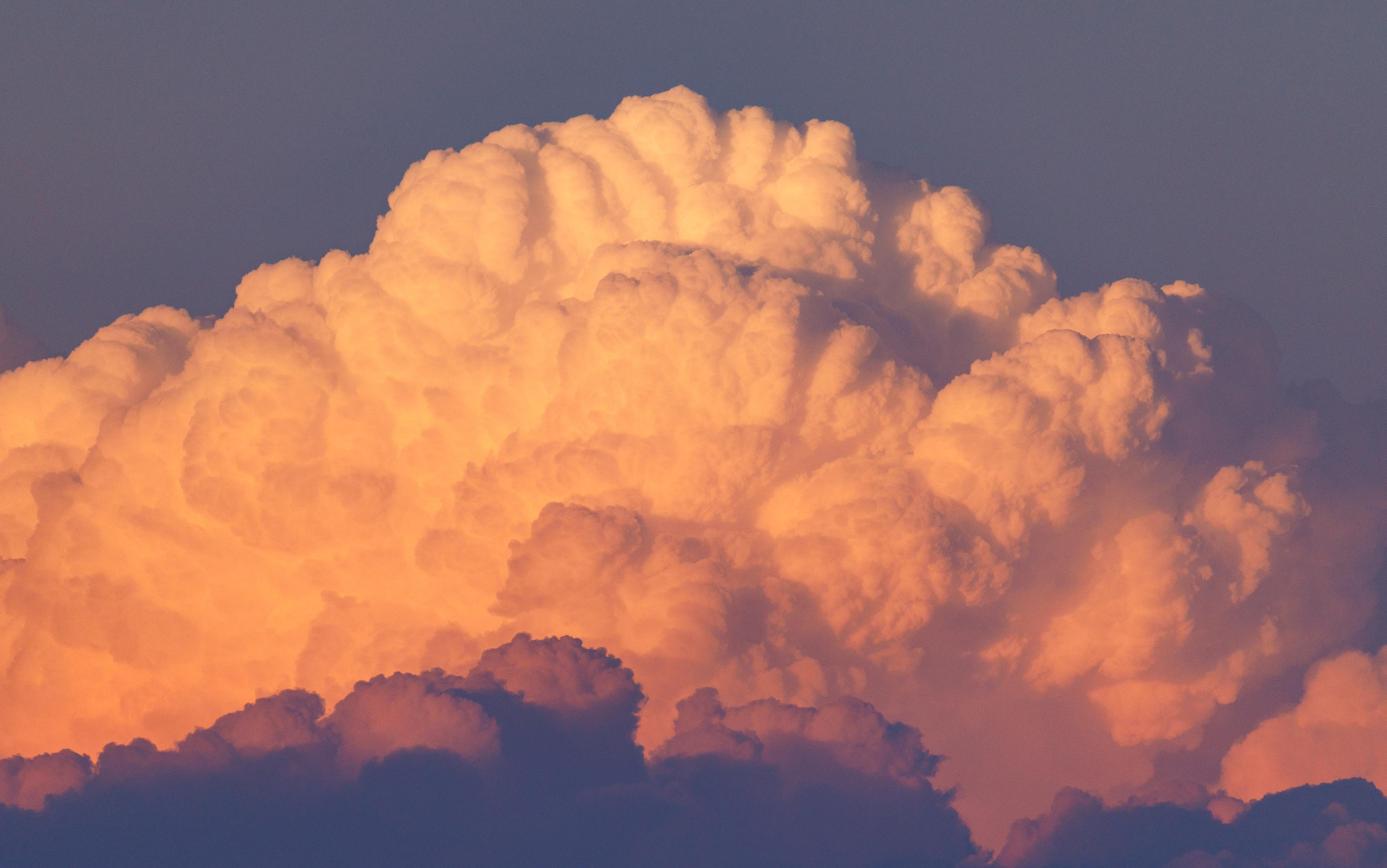 Orange and pink clouds billowing in the evening light