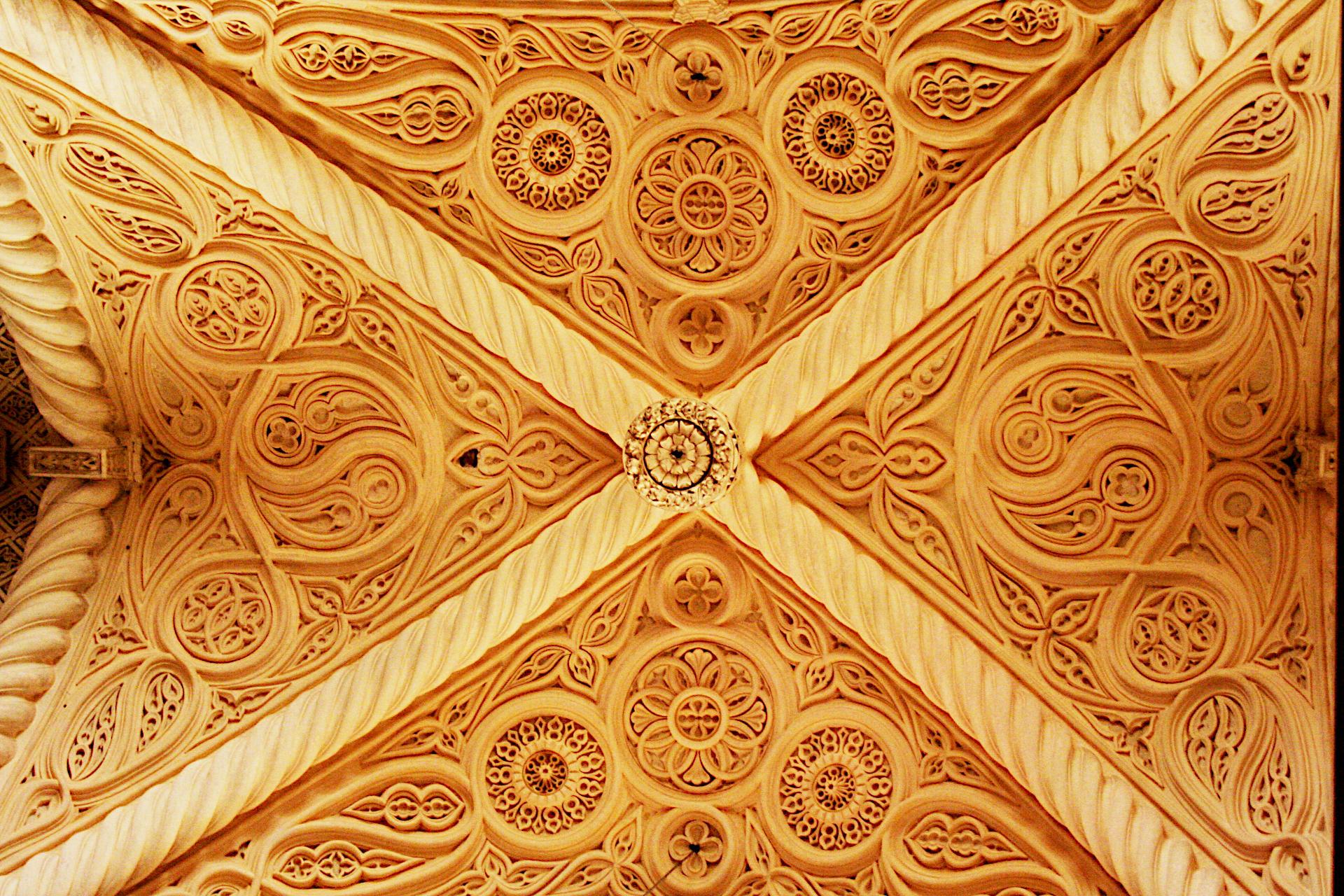 The intricately carved, golden-toned stucco ceiling of the Erice Cathedral (Chiesa Matrice, formerly Real Chiesa Madrice Insigne Collegiata di Erice) in Sicily, Italy. The vault features complex geometric and floral patterns arranged in a ribbed, crossed design. Originally dating back to the 14th century, the ceiling has been described as a unique artistic blend of Norman and Middle Eastern architectural styles.

Canon EOS 350D DIGITAL
ISO: 1600
Shutter Speed: 1/30
Aperture: 4.5

Lens: 18.0 - 55.0 mm
Focal Length: 35.0 mm (35 mm equivalent: 56.8 mm)
Hyperfocal Distance: 14.70 m
Field Of View: 35.2 deg

GPS Position: 38 deg 2' 12.00" N, 12 deg 35' 3.00" E

2006:04:28 11:10:54
Copyright: Copyright © Matthew Malthouse 2006
