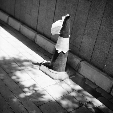Lucky LUCKY SHD 100 (6x6)

English 
A black and white photograph of a traffic cone on the street. The scene is strong in contrast thanks to the shadows cast by the trees and the sunlight.

中文
一张黑白照片.照片中的交通锥在人行道上.照片中描绘的场景因为阳光和叶子的影子,产生了巨大的反差.