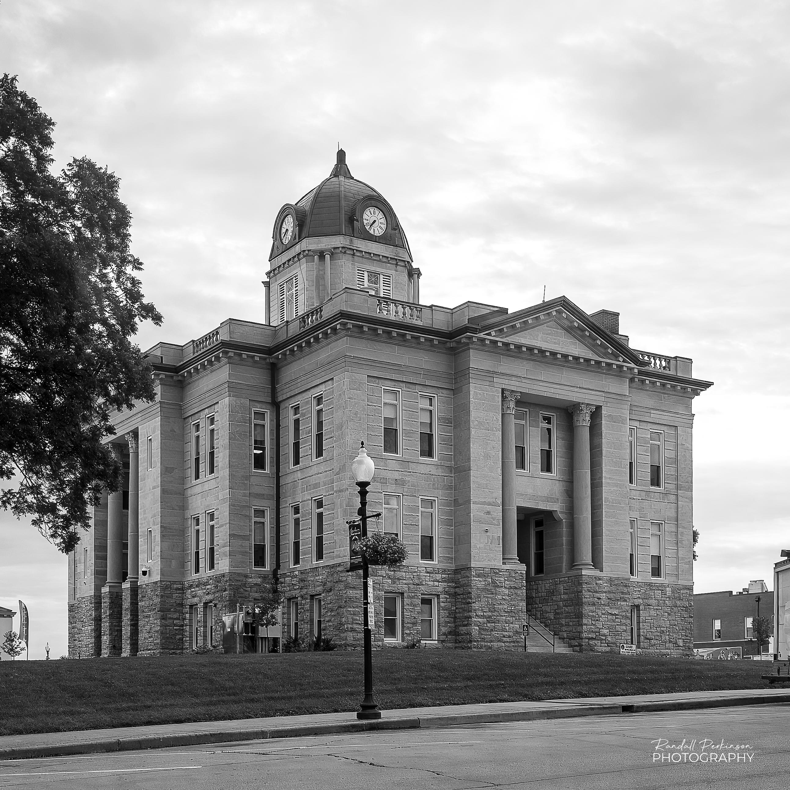 A black and white view of a stone three-story courthouse.