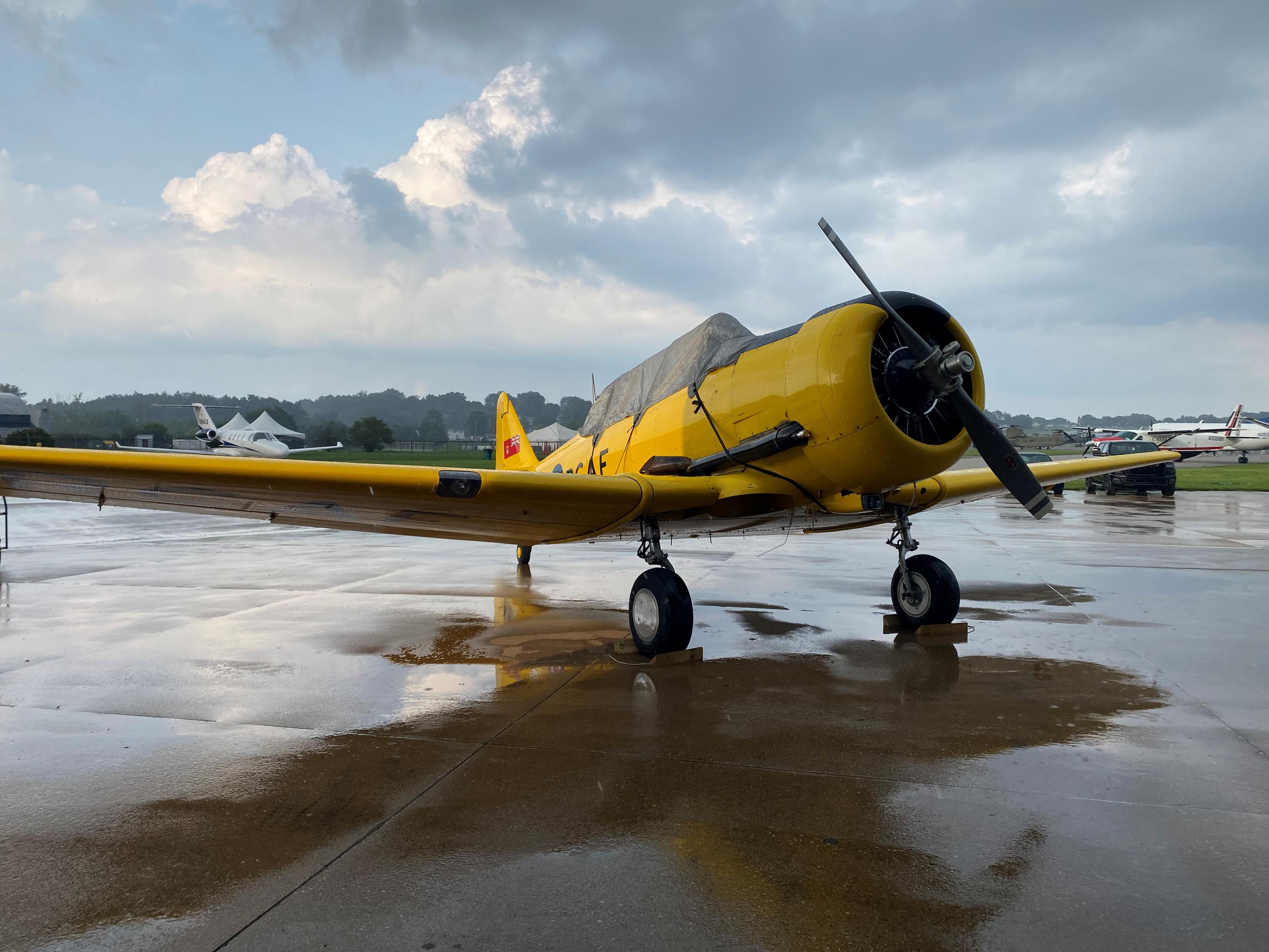 Color image, Canadian RCN TBM Avenger. Image shows a WWII era TBM Avenger in RCN livery, standing at Akron Municipal Airport in Akron, Summit County, Ohio, USA, appearing and performing at the Props & Pistons Festival., just after a passing rain shower.