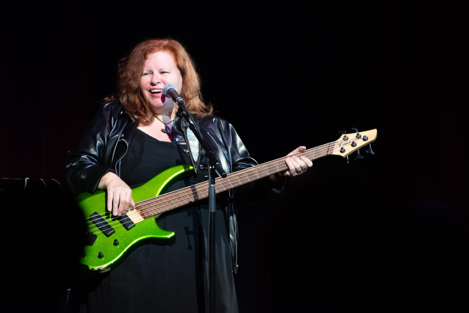 Suzie playing a sparkling green bass with fan-frets.