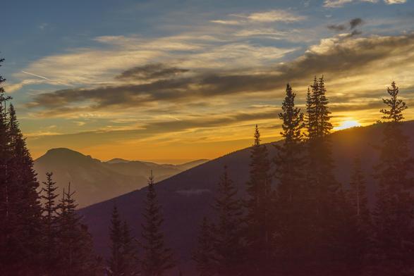 Photo from Rocky Mountain National Park. Looking East from Trail Ridge Road at a sign explaining that the elevation is 2 miles, 3.2km. The sun is just breaking over the ridge in front of me. October 2015.
