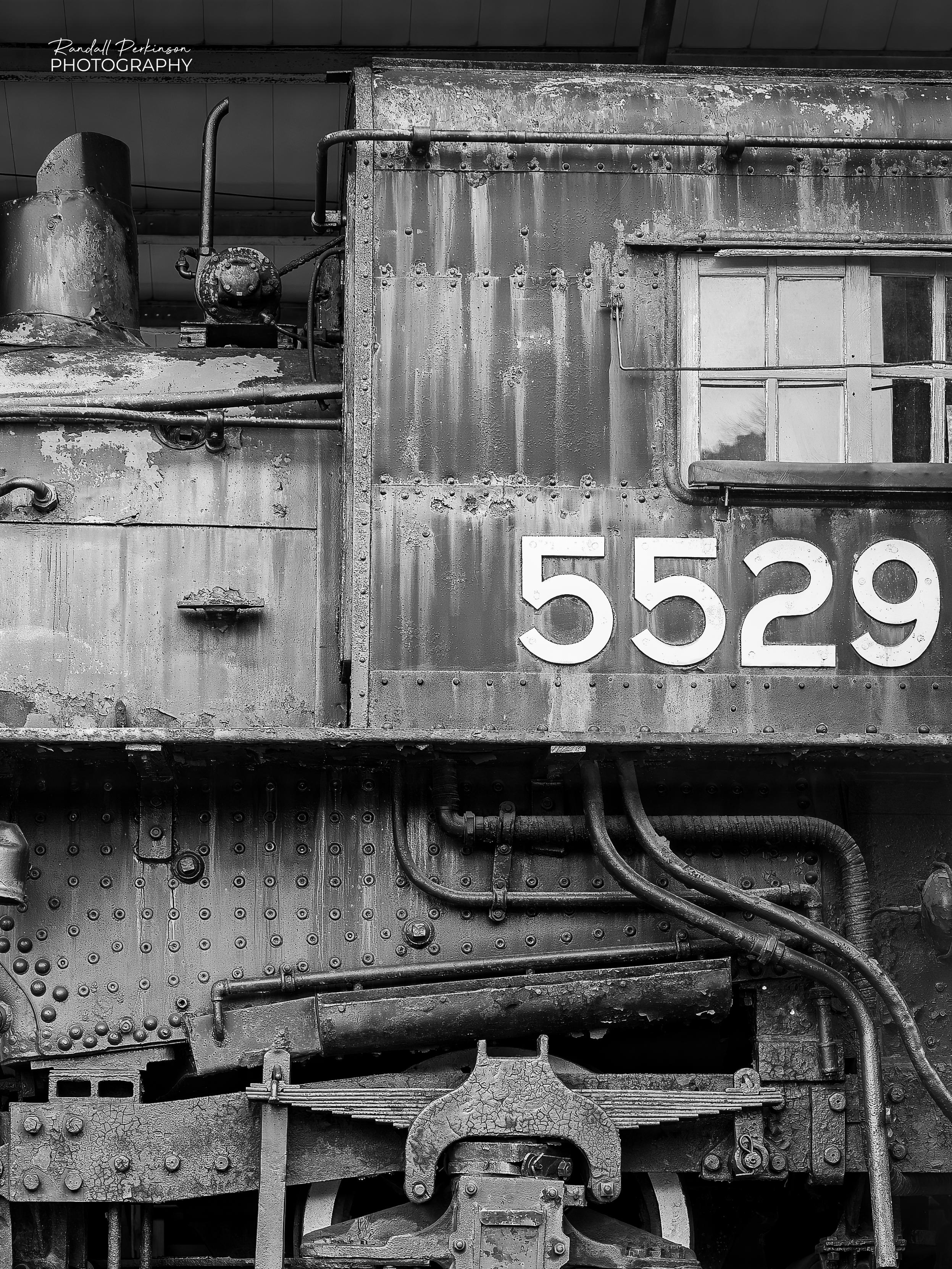 Side view of part of Canadian National No. 5529, a 4-6-2 "Pacific" type steam locomotive building in 1905 in Montreal, Canada.  It's a Class K-1-d medium passenger locomotive featuring 72" drive wheels and weighing over 346,000 pounds with its tender.  It was retired in the late 1950s and has been at the National Museum of Transportation since November, 1958.