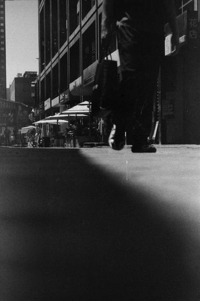 ERA 100 (FF)

English
A black and white photograph of a street scene. The photo is taken from a low angle. A pedestrian can be seen. There are sun-blocking umbrellas along the shops which constitute the bottom part of the building.

中文
一張街景的黑白照片.照片從低角度拍攝,可以看到行人.一些遮陽傘沿著商鋪拜訪.商鋪在樓房的底層.
