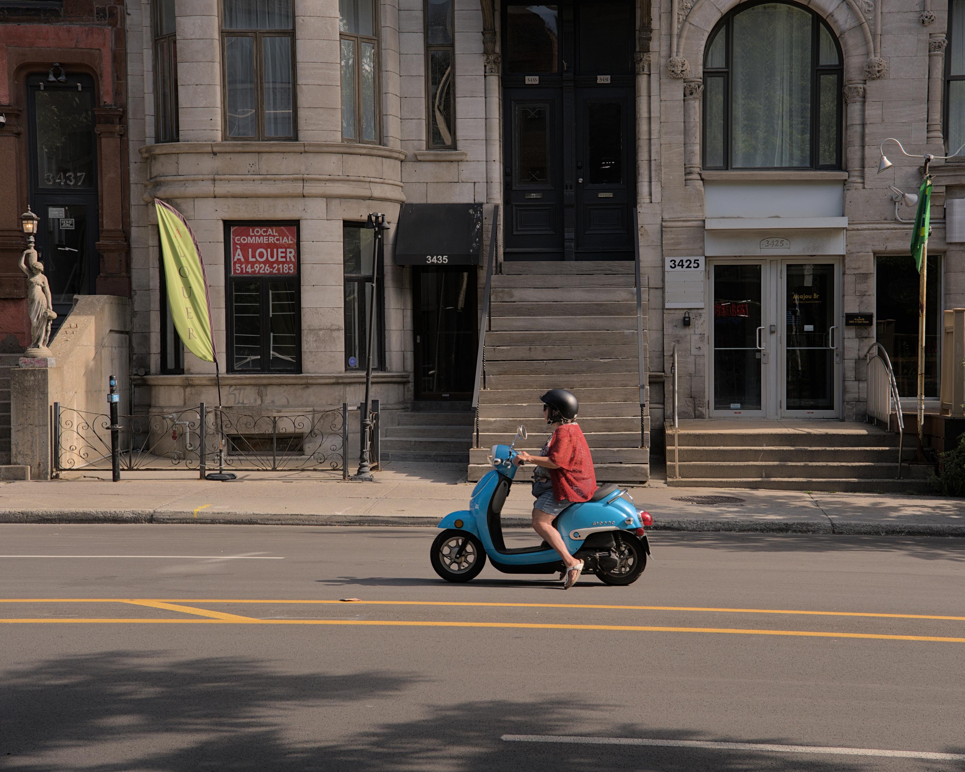 A woman on a Vespa scooter.
