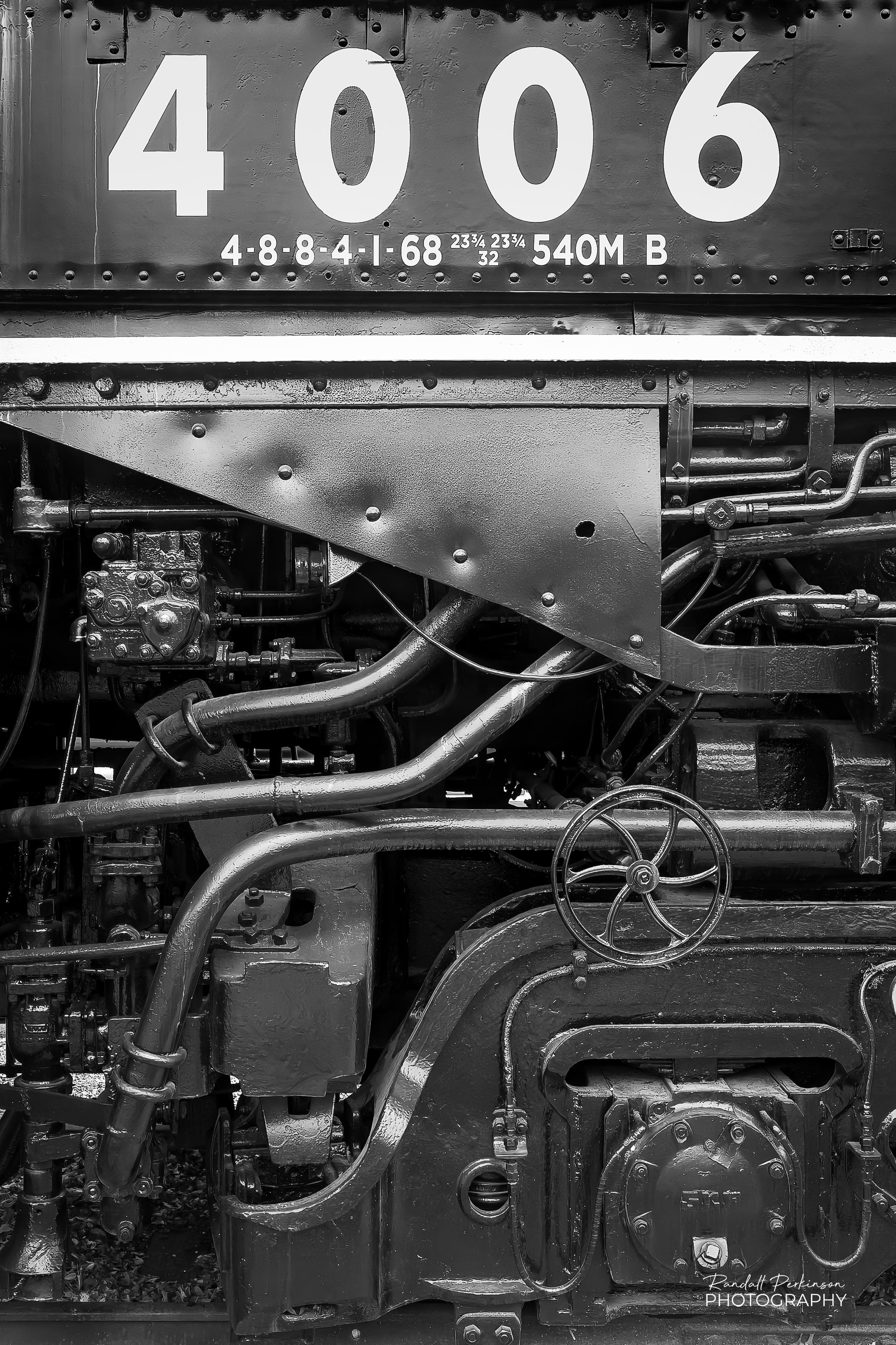 A side view of Union Pacific "Big Boy" locomotive 4006 showing the complex structure and piping below the cab.  "4006" is painted in large numbers and under that in smaller text is "4-8-8-4-1-68 23-3/4 23-3/4 32 540M B"