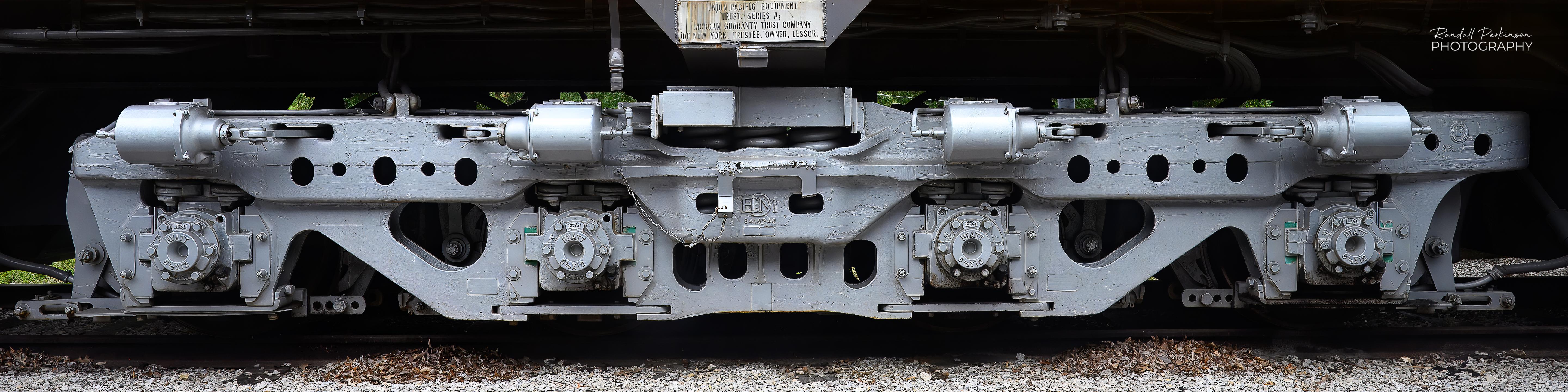 A very wide photo showing the massive 4 axle undercarriage of a large locomotive.