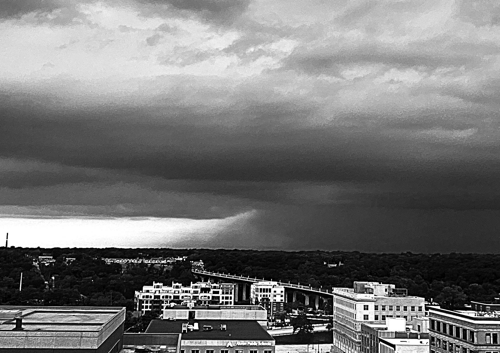 Monochrome image of heavy summer storms moving from northeast to southwest in Akron, Summit County, Ohio, USA, 3 September 2026. Image shows heavy rainclouds bursting north of downtown Akron, Summit County, Ohio, USA, with a heavy cumulus cloud deck raining hard over areas north and est of the city, downtown buildings and the All-America Bridge crossing the Little Cuyahoga River visible in the lower part of the image.
