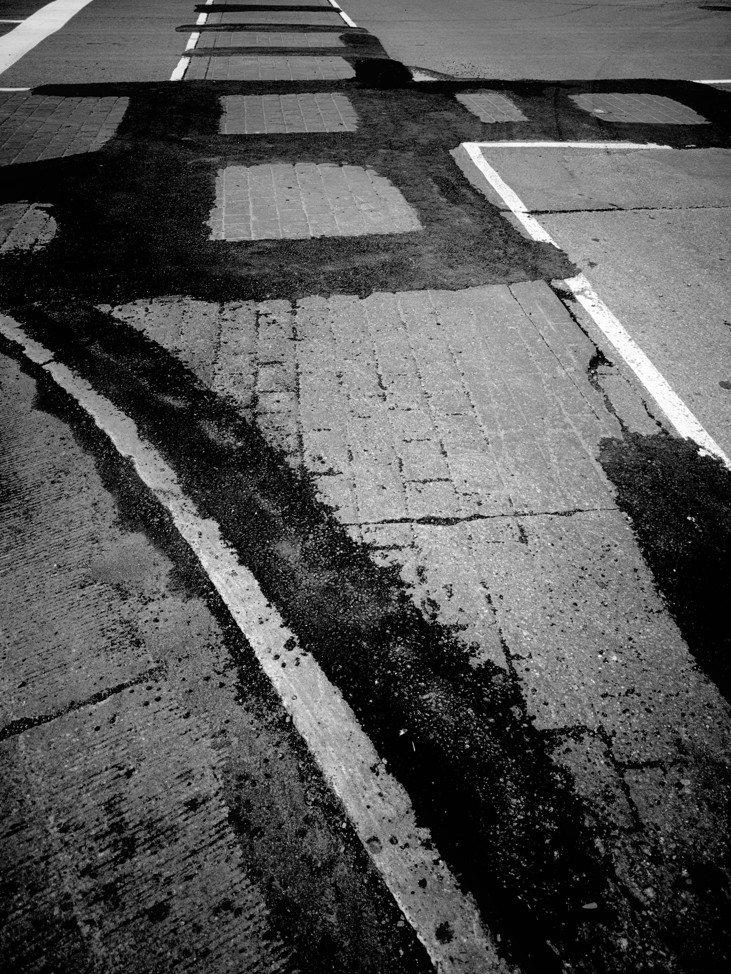 The local brick crosswalk, elegantly patched with asphalt.