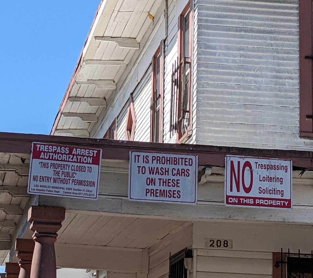 Several signs on a residence. One says It is prohibited to wash cars on these premises