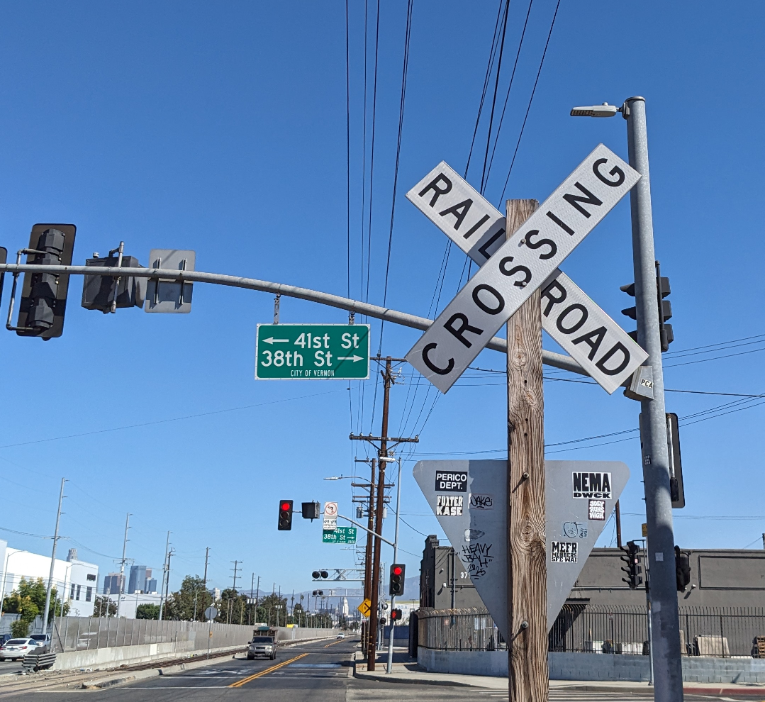 Old railroad crossing sign in the shadow of an X
