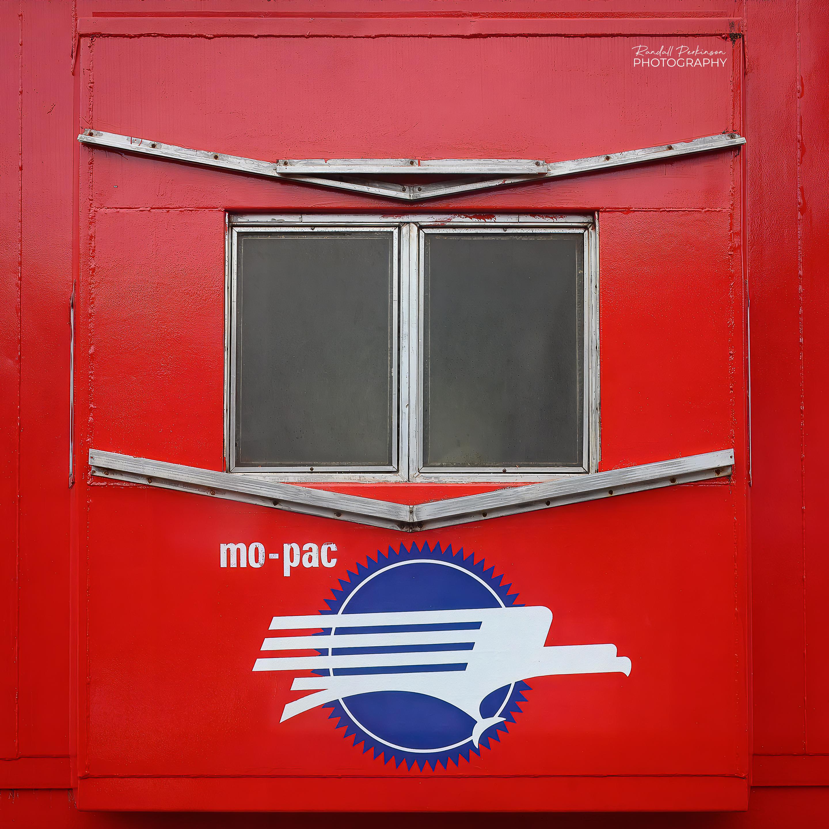 The logo of mo-pac, or Missouri-Pacific Railroad, on the side of a caboose.