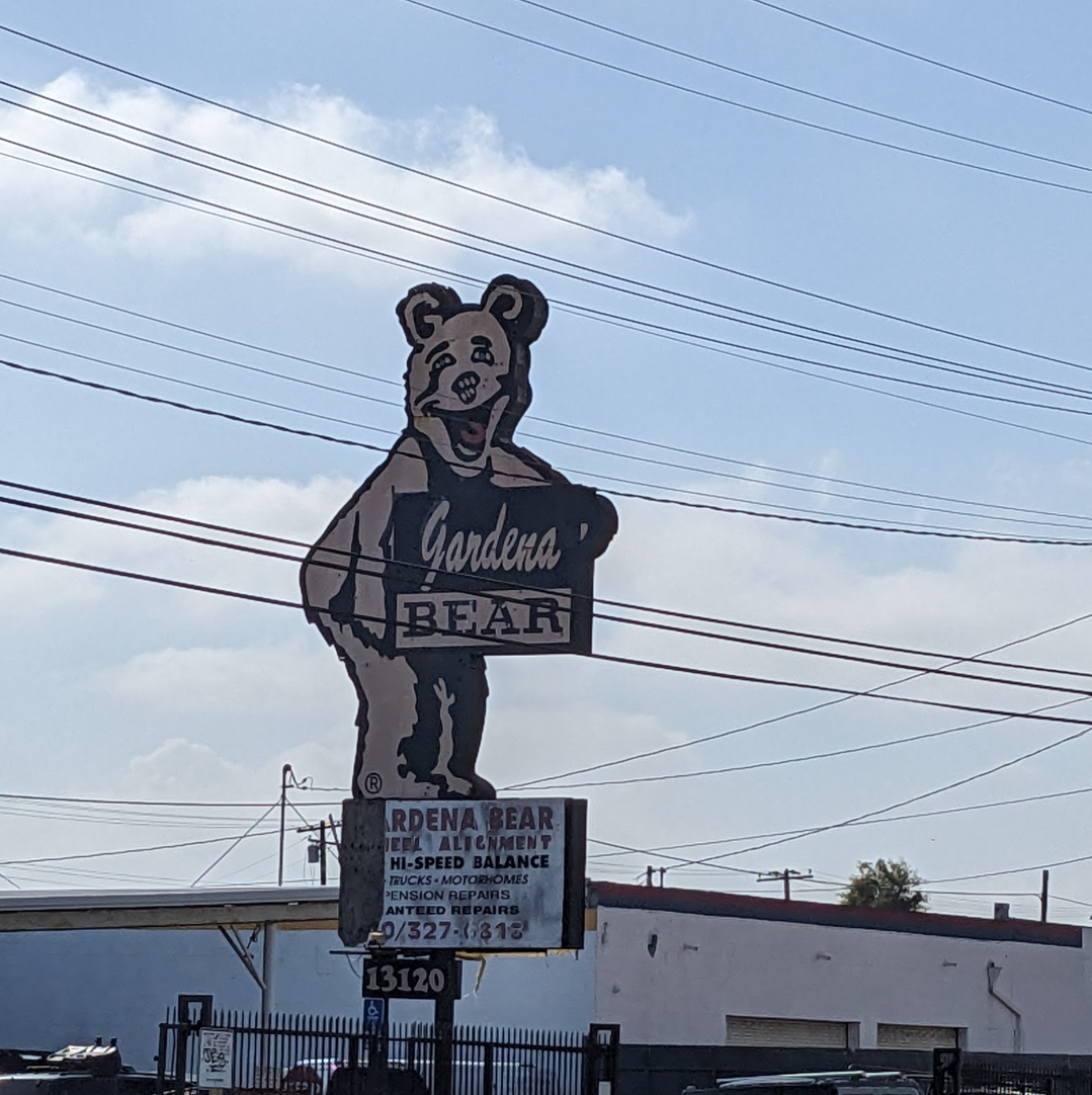 Big bear holding a sign that says Gardena Bear